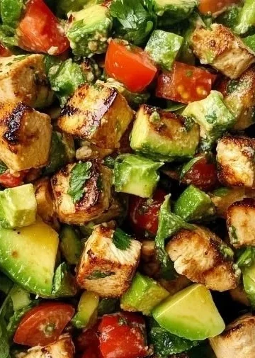 A delicious Avocado Chicken Salad with fresh ingredients and garnishes.