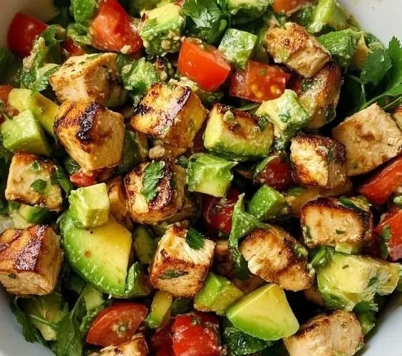 A delicious Avocado Chicken Salad with fresh ingredients and garnishes.