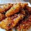 Baked Crunchy Hot Honey Chicken served on a plate with garnishes.