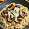 Creamy mushroom risotto served in a bowl, garnished with parsley.