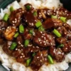 Crock Pot Korean Beef dish garnished with green onions and served with rice