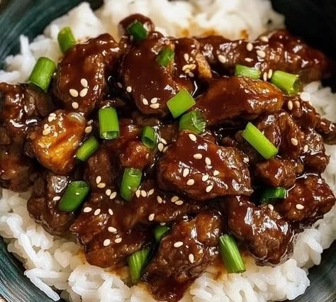 Crock Pot Korean Beef dish garnished with green onions and served with rice