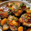 Jalapeño Peach Glazed Chicken garnished with fresh herbs on a serving plate