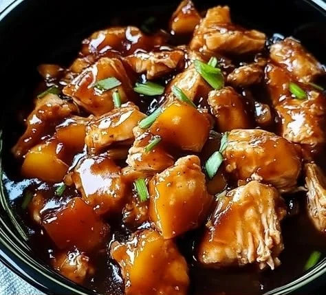 Sweet Hawaiian Crockpot Chicken served in a bowl with tropical garnishes