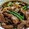 Slow cooker Mongolian beef served with rice and vegetables.