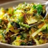 Plate of crispy sautéed shredded Brussels sprouts garnished with herbs