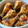 Savory Crock-Pot chicken drumsticks served on a plate with herbs.