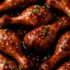 Slow Cooker Asian Glazed Chicken Drumsticks garnished with sesame seeds and green onions