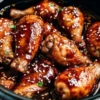 Slow Cooker Asian Glazed Chicken Drumsticks garnished with sesame seeds and herbs