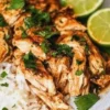 Slow cooker cilantro lime chicken served with fresh lime and cilantro garnish.