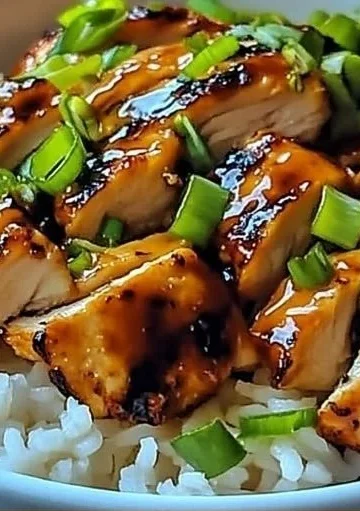 Spicy Maple Chicken served with coconut rice on a white plate, garnished with herbs.