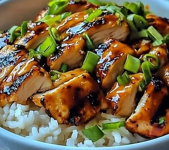 Spicy Maple Chicken served with coconut rice on a white plate, garnished with herbs.