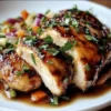 Sticky apple cider chicken served with fresh herbs and caramelized apples