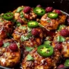 Delicious Sweet & Spicy Jalapeño Raspberry Chicken dish garnished with fresh herbs