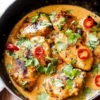 Thai Coconut Honey Lime Chicken garnished with lime slices and herbs on a plate.