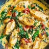 Creamy Tuscan Chicken served with herbs and vegetables on a plate